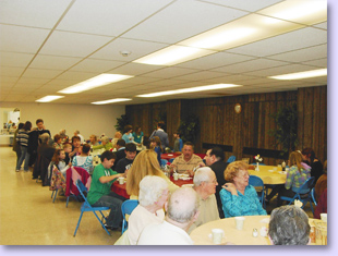 people at tables for pancake supper