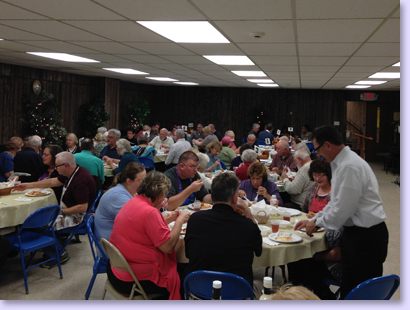people at tables for church dinner